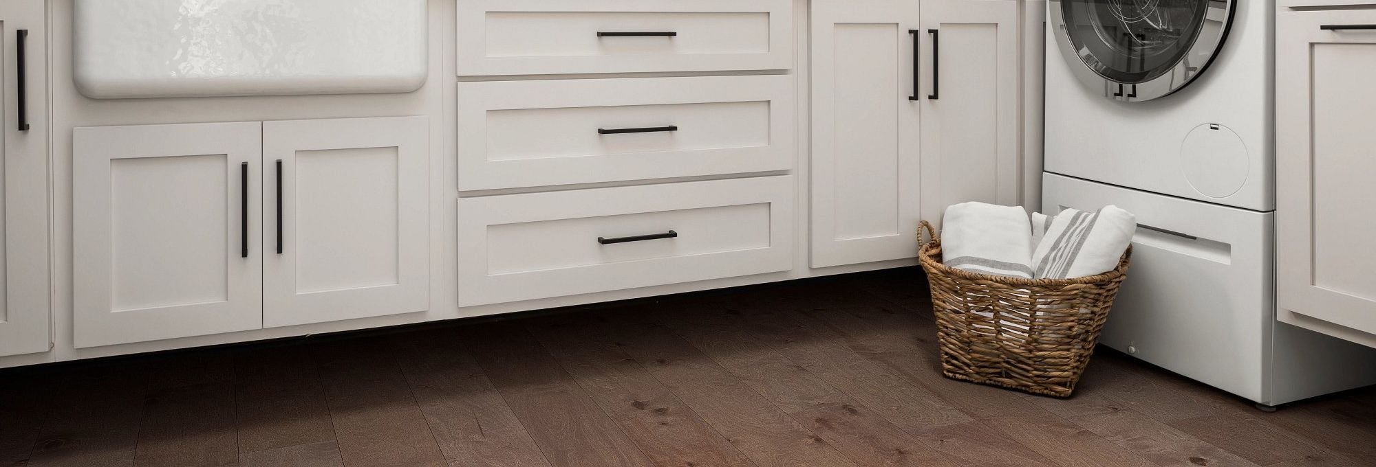 Kitchen with a washer and a basket of laundry on the hardwood flooring from Simonian Flooring Inc in Village, NV